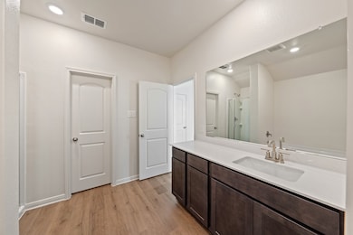 Bathroom featuring light wood-style floors, a stall shower, vanity, and recessed lighting