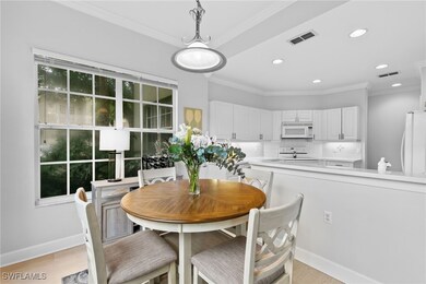 Dining area with crown molding and light hardwood