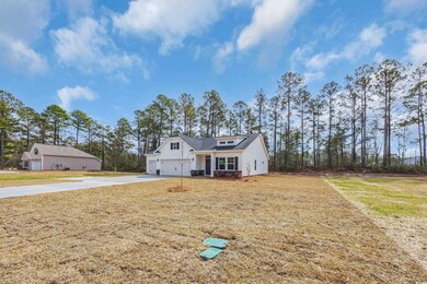 View of front of house with concrete driveway and a front lawn