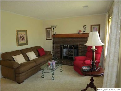 Livingroom features gas log fireplace with brick s