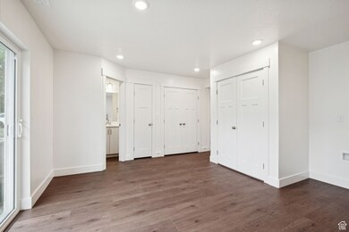 Unfurnished bedroom featuring dark wood-style floors, multiple closets, access to exterior, and recessed lighting