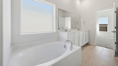 Full bathroom with double vanity, a bath, and light tile patterned floors