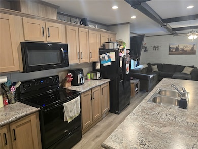 Kitchen with black appliances, open floor plan, recessed lighting, light wood-style flooring, and ceiling fan