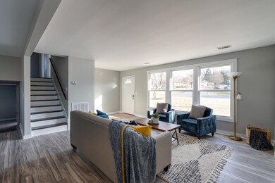 Another view of the living room and entry. 3 bedrooms are the up the stairs and the primary bedroom is down (not fully a basement, only partially underground). 