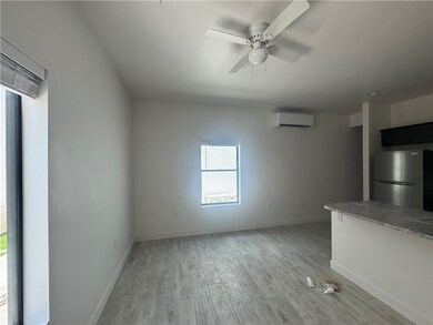 Unfurnished living room featuring a wall unit AC,