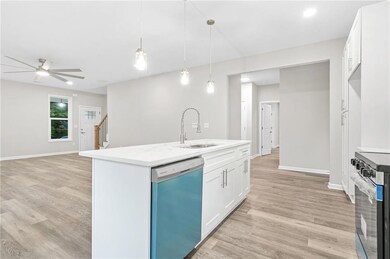 Kitchen with dishwasher, electric stove, light wood finished floors, and white cabinets
