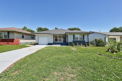 Ranch-style home featuring driveway, a garage, and a front yard