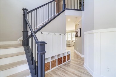 Stairs with wood finished floors, a towering ceiling, and baseboards