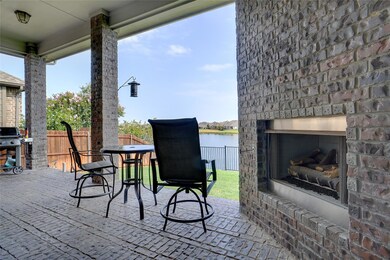 View of patio featuring an outdoor brick fireplace