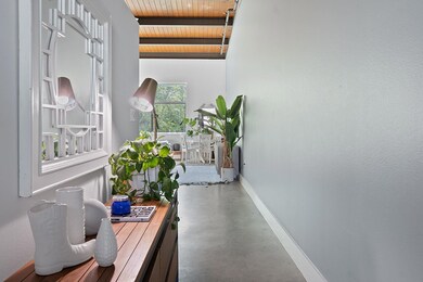 Hallway with finished concrete floors, beamed cei