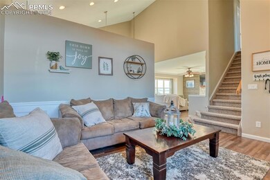 Living room featuring ceiling fan, high vaulted ce
