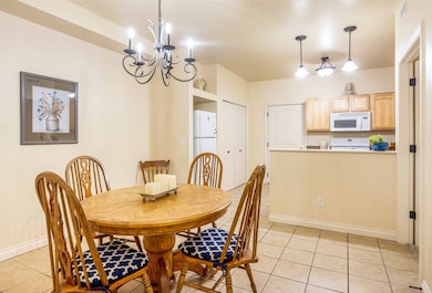 Dining space featuring light tile patterned flooring and a chandelier