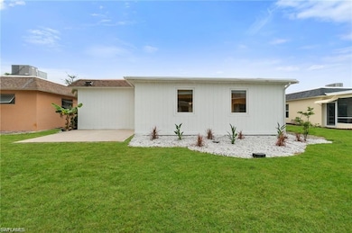 Rear view of house featuring a lawn, a patio, and 