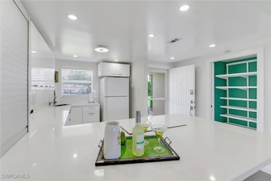 Kitchen featuring freestanding refrigerator, a sin