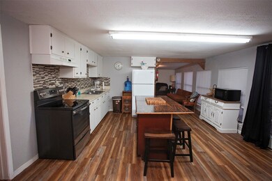 New flooring. View of kitchen through to living room.