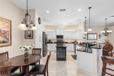 Kitchen featuring stainless steel appliances, sink, tasteful backsplash, a center island, and white cabinets