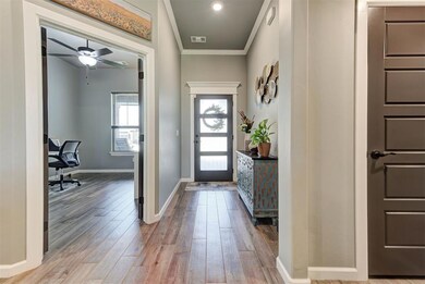 Foyer featuring ornamental molding, wood finished floors, baseboards, and ceiling fan