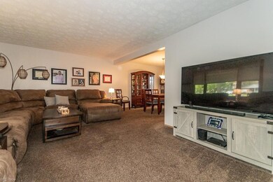 Living room featuring a textured ceiling, beam cei