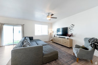 Living area featuring healthy amount of natural light, ceiling fan, and light wood-type flooring