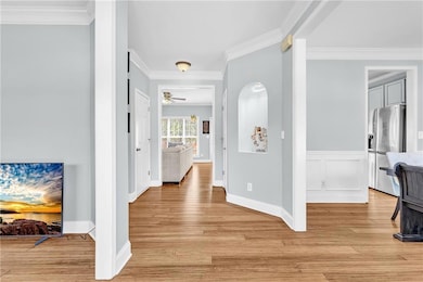 Hallway with light wood-style flooring, a wainscot
