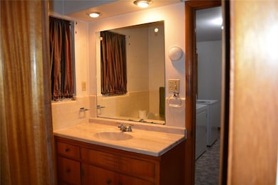 Bathroom featuring separate washer and dryer and vanity