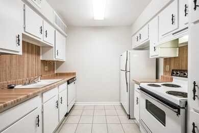 The kitchen features tile floors and laminate coun