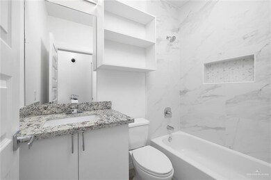 Bathroom with vanity, toilet, and shower / washtub combination