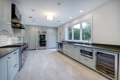 An Arte light fixture, recessed LEDs and undercabinet lighting provide the perfect illumination for every task, while a pull-out trash receptacle, double basin sink, Dornbracht fixtures and water filtration add convenience. Between the utility and kitchen is a sleek console vanity, Dornbracht faucet and Toto commode fill the powder room.