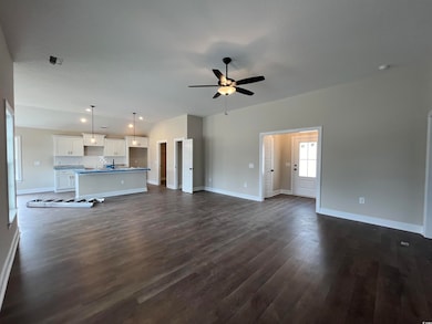 Unfurnished living room featuring dark hardwood / 