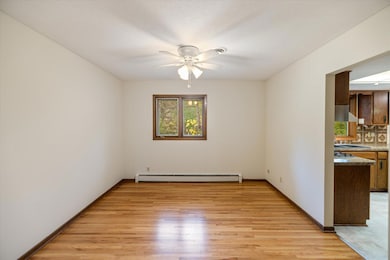 Dining room with backyard view and hardwood floors.