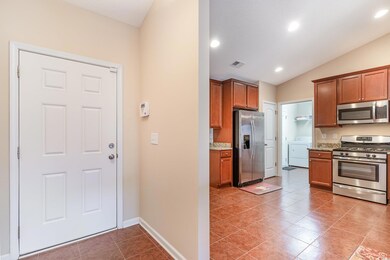 Kitchen with brown cabinets, washer / dryer, visib