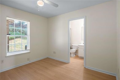 Unfurnished bedroom featuring ensuite bath, basebo