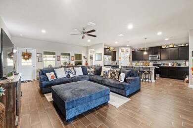 Living room featuring recessed lighting, wood tiled floors, and a ceiling fan