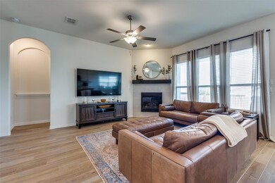 Living room with a fireplace, ceiling fan, and lig