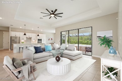 Living area featuring a raised ceiling, a ceiling fan, recessed lighting, and light tile patterned flooring