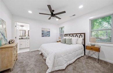 Bedroom featuring light carpet, connected bathroom