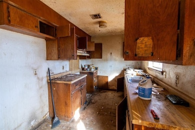 Kitchen with under cabinet range hood and brown cabinets