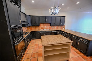 Kitchen with a kitchen island, backsplash, a chandelier, crown molding, and recessed lighting