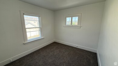 Spare room with dark colored carpet and baseboards