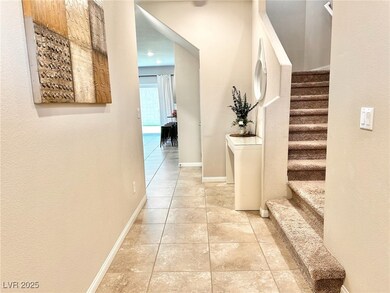 Hall with light tile patterned floors, stairs, and