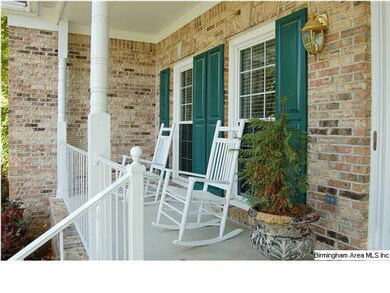 The front porch is surrounded by mature trees, wel