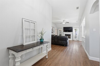 Hallway with light wood-type flooring and arched walkways