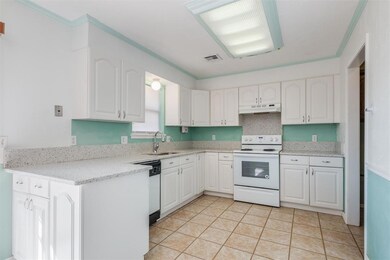 Kitchen featuring white cabinets, light tile floor