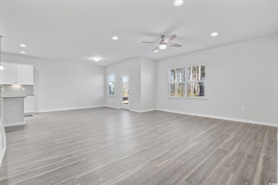 Unfurnished living room with ceiling fan and light