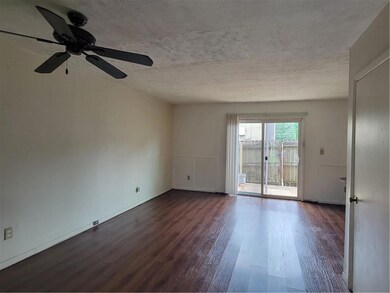 Spare room with dark wood-style floors, ceiling fan, and baseboards
