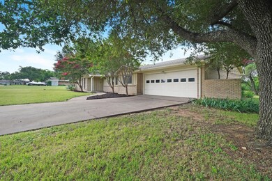 Ranch-style house featuring a front yard and a gar