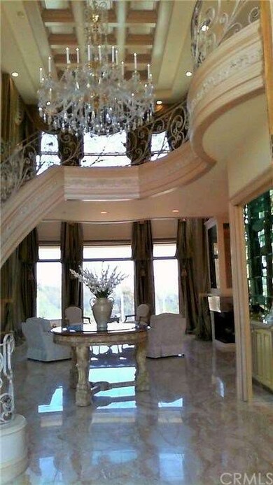 Foyer with custom staircase and chandelier.