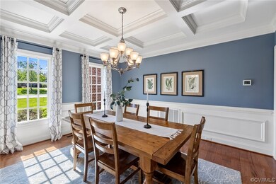 Dining room features coffered ceiling, triple crow