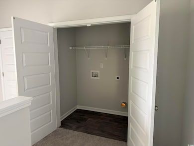 Laundry room with hookup for a washing machine, electric dryer hookup, and dark wood-style floors