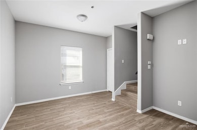 Unfurnished room featuring wood finished floors and stairs